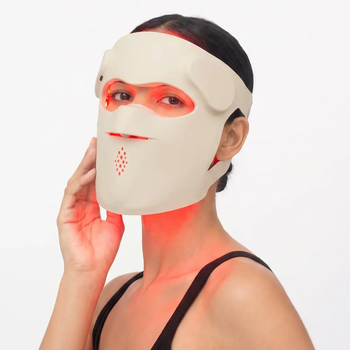Woman wearing the Dr. Renú SpectraLift Advanced LED mask during a red-light session, the silicone mask covering her face from forehead to chin with red light visible on her neck